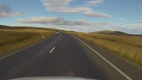 Straßenzeitraffer-In-Island.-Blick-Von-Oben-Auf-Ein-Auto,-Das-An-Einem-Sonnigen-Tag-Fährt